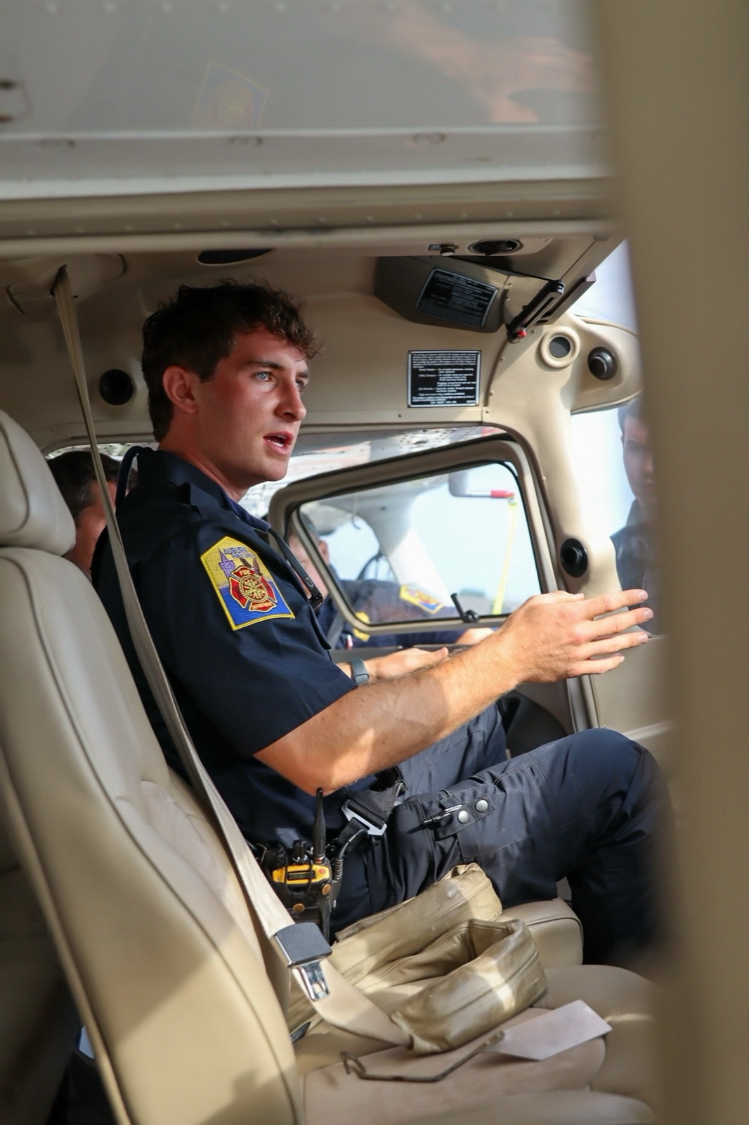 Niko Stavros in his fire department uniform teaching aviation emergency response inside an aircraft