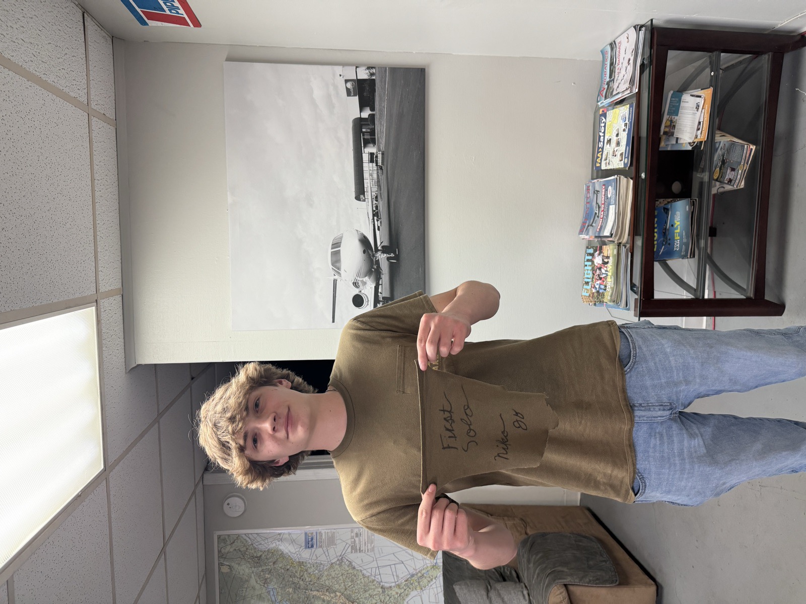 A smiling student holding their cut shirt-tail after a first solo flight