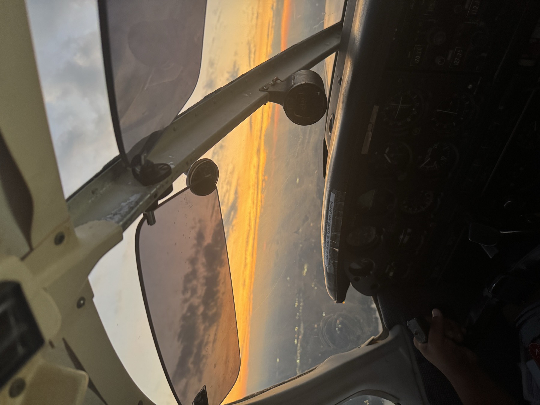 Sunset over the horizon seen from the cockpit during a training flight